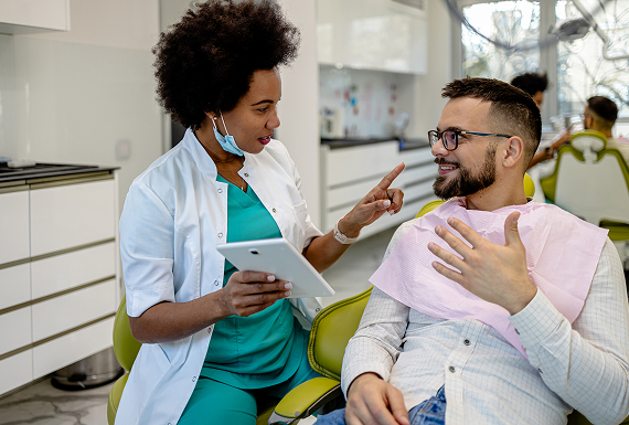 A dentist speaking with a patient