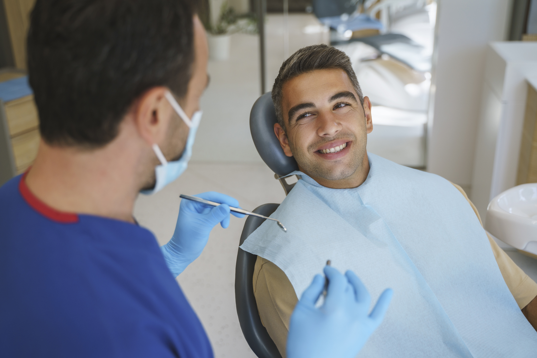 A smiling patient in a dental chair with a periodontist
